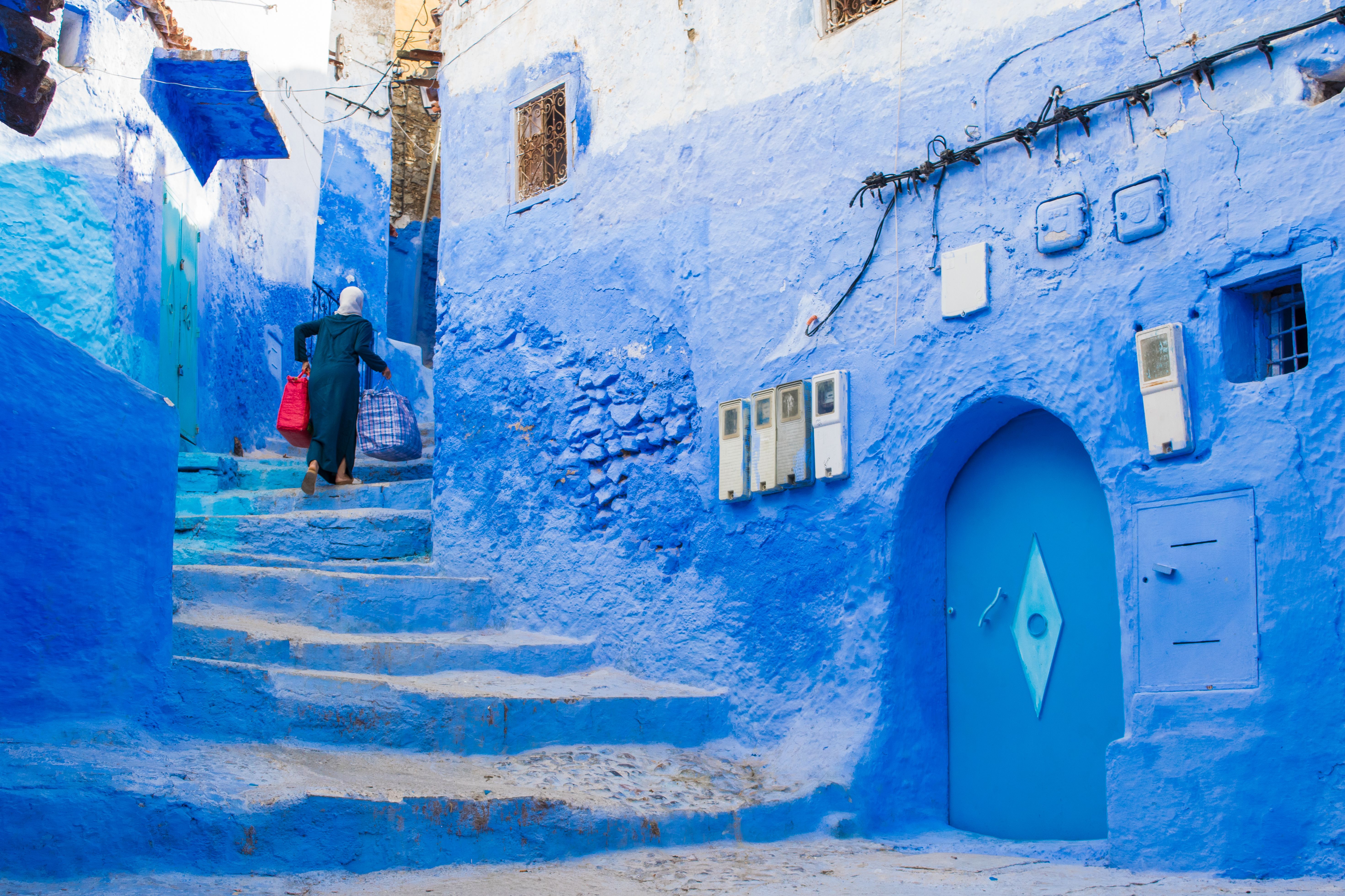 Narrow street with blue painted walls and stairs in the medina of city of Chefchaouen, Morocco, morocco tours from tangier